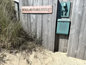 et dørskilt på et sommerhus ved klitter i skagen