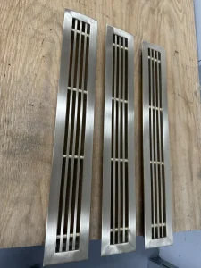 Et par messing riste til et afløb