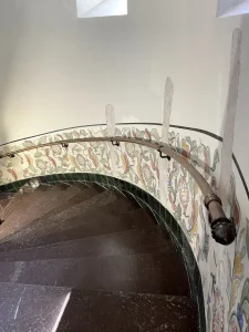 En bruneret gelænder rundstok som følger en kurvet væg