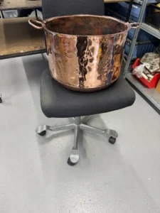 en renoveret kobber gruekedel på en kontorstol